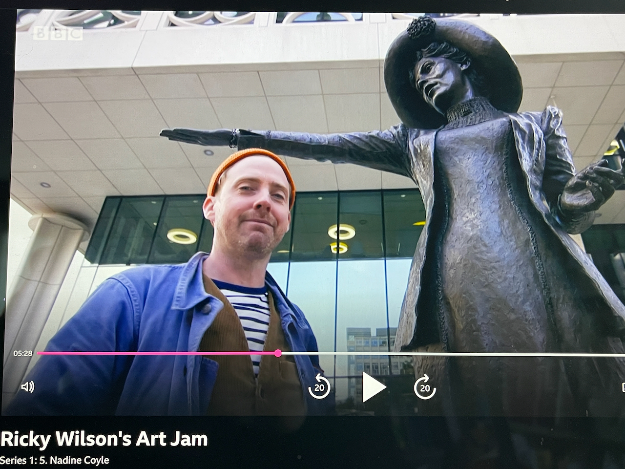 Ricky Wilson smiles under the Our Emmeline statue in Manchester