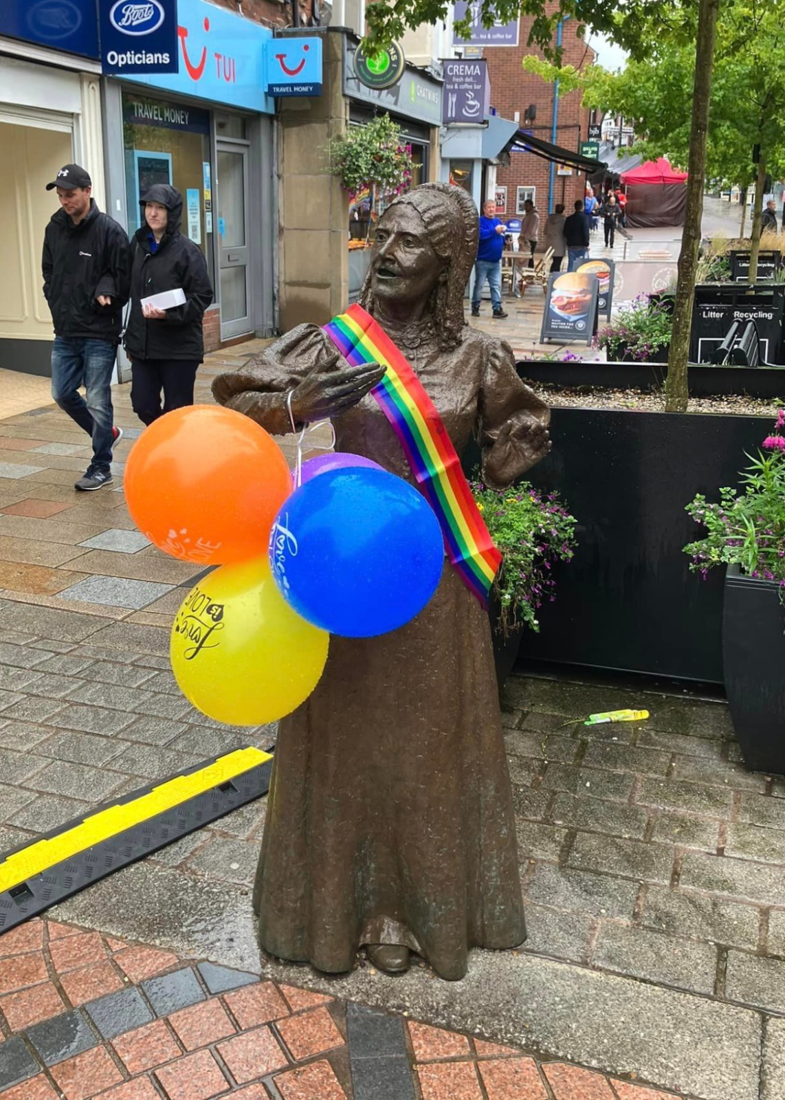 The bronze statue of Our Elizabeth wears a Pride rainbow sash and has multi-coloured balloons attached to her arms